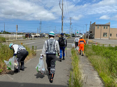 新泻分公司新泻管理办公室集团的员工正在沿着龟田乡的高速公路清理。的照片