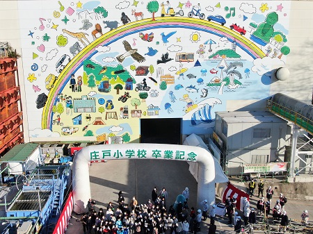 横浜市立庄戸小学校6年生の卒業記念、防音ハウスに描かれた壁画には虹を道路に見立て、車や人、動物、鎌倉の大仏や江の島、金沢動物園、サーファーなど沿線地域にちなんだカラフルな絵が一面に描かれているの写真