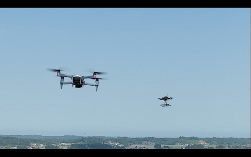A photo of a drone in automatic flight (back right) avoiding a collision with another drone (front left)