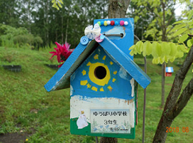Each birdhouse is a handmade photo of a child