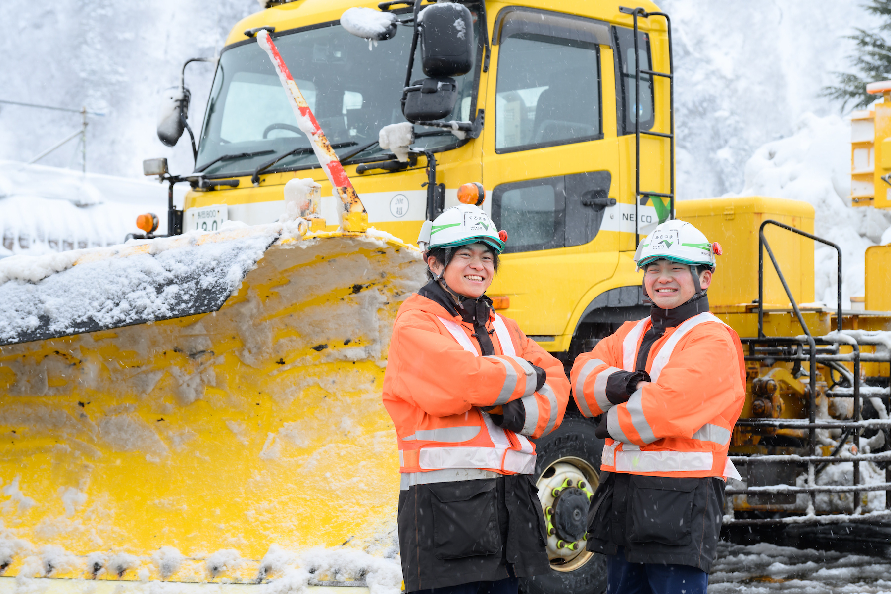 除雪トラックを背景に働く朝妻さんたち